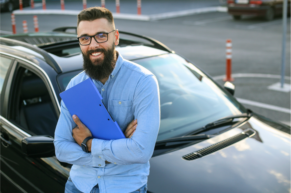 Driving instructor standing beside a car